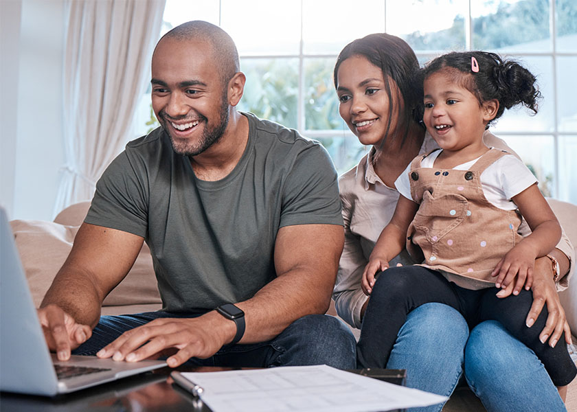 Smiling family creating a budget on laptop